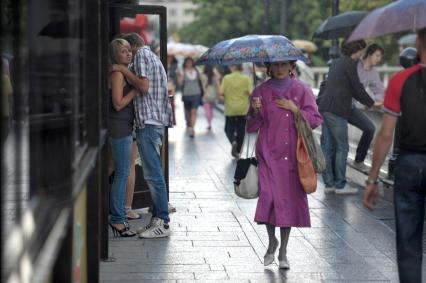 Влюбленная парочка спряталась от дождя под крышей кафе, Москва, 22 июня 2011 года