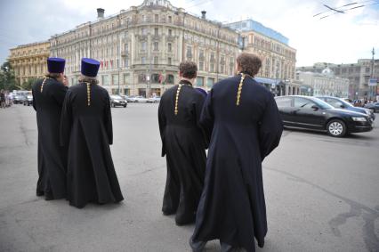 Служители церкви в рясах стоят у дороги в ожидании машины, Москва, 22 июня 2011 года