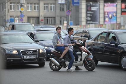 Молодые люди на мопеде едут по дороге, Москва, 28 июня 2011 года