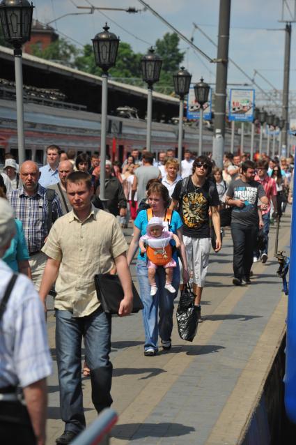 Пассажиры на железнодорожном Ярославском вокзале в Москве летом. Люди идут по перрону. 31 мая 2011 г.