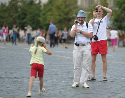 Туристы фотографируют на Красной площади, Москва, 14 июля 2011 года.