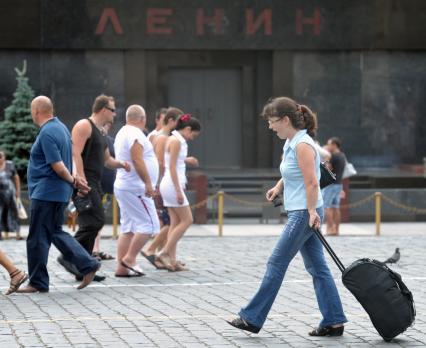 Девушка с чемоданом идет по Красной площади, Москва, 14 июля 2011 года.