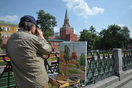 Художник рисует на мольберте Кремль, Москва, 16 июля 2011 года.