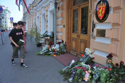 Люди приносят цветы к посольству Норвегии в память о погибших в двойном теракте в Осло. Москва. 24 июля 2011 года.
