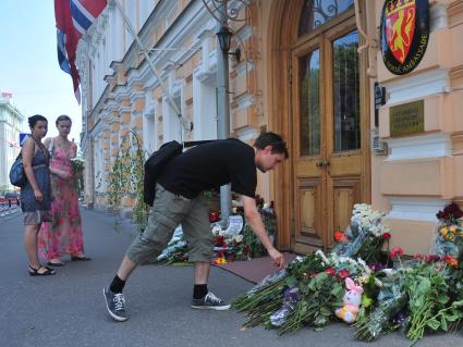 Люди приносят цветы к посольству Норвегии в память о погибших в двойном теракте в Осло. Москва. 24 июля 2011 года.