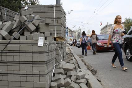 Укладка тротуарной плитки на улице города. Москва. 10 августа 2011 года.