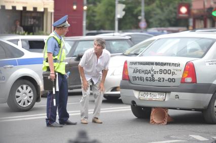 Полицейский беседует с нарушителем- водитель наехал на предупреждающий о ремонтных дорогах знак, Москва, 26 июля 2011 года.