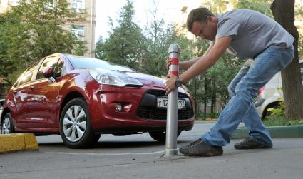 Молодой человек ломает парковочный столбик. 17 августа 2011 года.