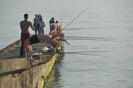 г.Сочи. Рыбаки на пирсе. Рыбалка. Мужчина прыгает в море. Море  Развлечение, отдых, отпуск. 14 июня 2011г.