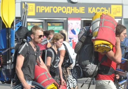 Группа молодых людей идут по Ярославскому вокзалу со снаряжениями для похода- палатками, спальными мешками и надувными лодками, 29 августа 2011 года.