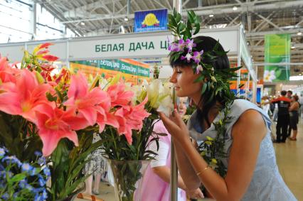 Девушка нюхает лилии в выстовочном павильоне. 31 августа 2011 года.