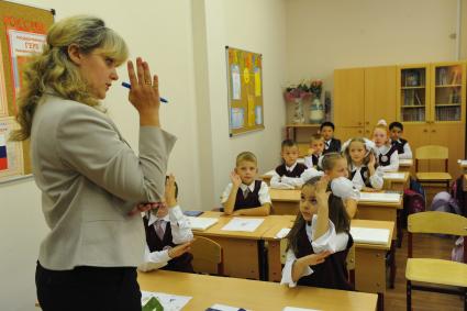 День знаний в российских школах. На снимке: первоклассники и преподаватель во время первого урока. 1 сентября 2011 года