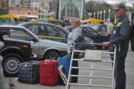 Женщина с багажом ожидает такси. 16 сентября  2011 года.