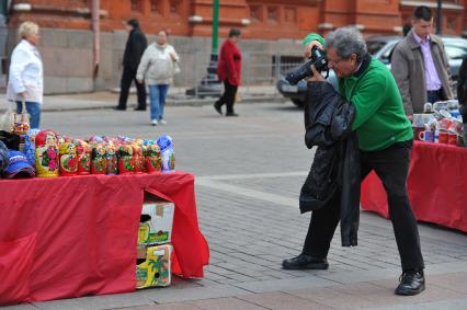 Жанровая фотография. Турист фотографирует сувенирную продукцию. Москва. 20 сентября 2011 года.