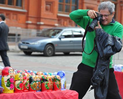 Жанровая фотография. Турист фотографирует сувенирную продукцию. Москва. 20 сентября 2011 года.