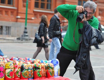 Жанровая фотография. Турист фотографирует сувенирную продукцию. Москва. 20 сентября 2011 года.