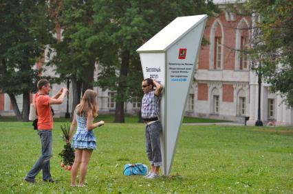 В парке ЦАРИЦЫНО установлена Wi-Fi антенна на солнечной батарее. Люди фотографируются возле Wi-Fi антенны.  04 июля 2011 года.