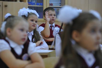 День знаний в российских школах. На снимке: мальчик тянет руку. 1 сентября 2011 года