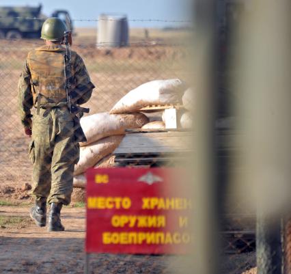 На снимке: Содат охраняет склад с боеприпасами. На табличке надпись: Место хранения оружия и боеприпасов. Полигон КАПУСТИН ЯР_ во время учений ЦЕНТР-2011. 20 сентября 2011 года.