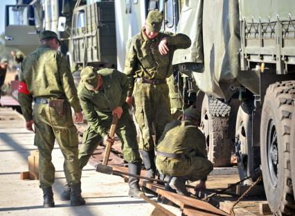 На снимке: Транспортировка техники на полигон. Солдаты снимают стопорные доски. Учения ЦЕНТР-2011 на полигоне КАПУСТИН ЯР_. 20 сентября 2011 года.