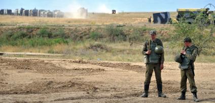 На снимке: Содаты стоят на поле, мимо проходит военная техника. Учения ЦЕНТР-2011 на полигоне КАПУСТИН ЯР_. 20 сентября 2011 года.