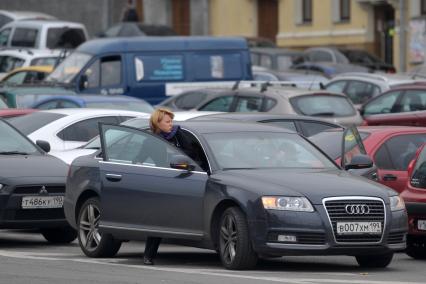 Женщина садится в автомобиль. 22 сентября 2011 года.
