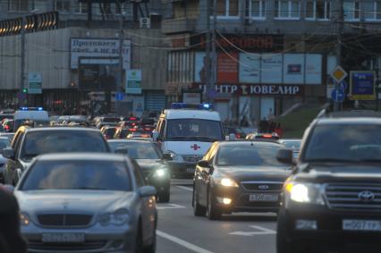 Машины стоят в автомобильной пробке. На снимке: машина станции скорой помощи движется в автомобильном потоке. 30 сентября 2011 года.