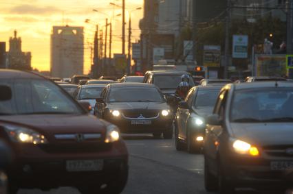 Машины стоят в автомобильной пробке. На снимке: мотоциклист движется в автомобильном потоке. 30 сентября 2011 года.