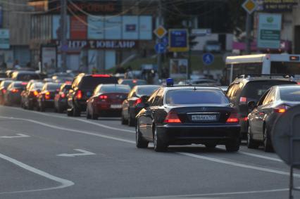 Машины стоят в автомобильной пробке. На снимке: автомашина с проблесковым маячком в автомобильном потоке. 30 сентября 2011 года.