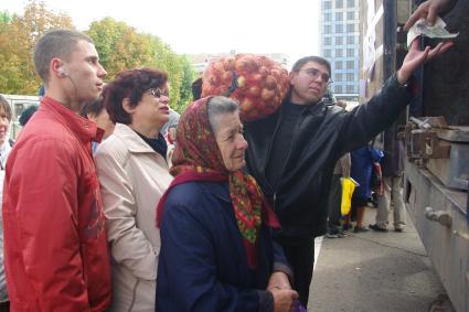 Мужчина покупает мешок лука на овощной ярмарке, 3 сентября  2011 года.