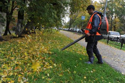 Рабочий убирает листву. Москва. 11 октября 2011 года.