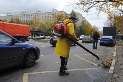 Рабочий убирает листву. Москва. 11 октября 2011 года.