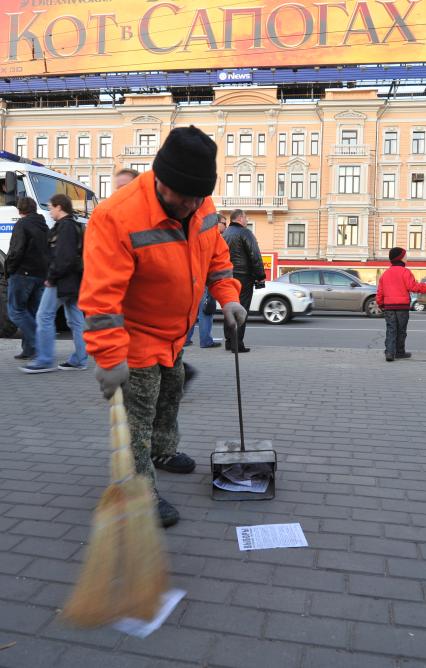 Дворник убирает с тротуара листовки против выборов, Москва, 18 октября  2011 года.