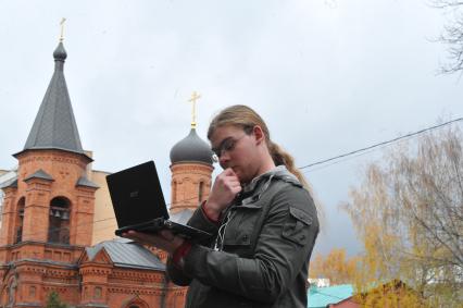 Храм святителя Митрофана Воронежского (Митрофаниевская церковь). На снимке: молодой человек с ноутбуком. 22 октября 2011 года.