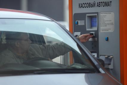 Мужчина оплачивает стоянку. Парковка в Шереметьево. Охраняемая платная автостоянка. Кассовый автомат. 26 октября 2011 г.