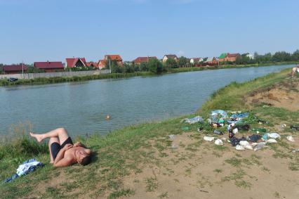 Жанровая фотография. Мужчина загорает на берегу реки. Деревня Вялки. Раменский район МО. 14 августа 2011 года.