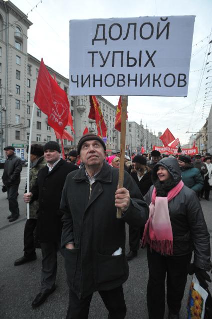 Во время шествия, приуроченного к 94-ой годовщине Октябрьской революции, на Тверской улице. На снимке: участник шествия держит лозунг ДОЛОЙ ТУПЫХ ЧИНОВНИКОВ. 07 ноября  2011 года.