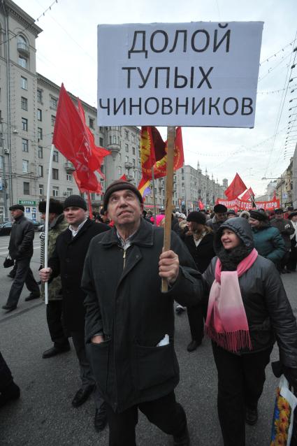 Во время шествия, приуроченного к 94-ой годовщине Октябрьской революции, на Тверской улице. На снимке: участник шествия держит лозунг ДОЛОЙ ТУПЫХ ЧИНОВНИКОВ. 07 ноября  2011 года.