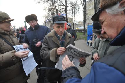 Во время шествия, приуроченного к 94-ой годовщине Октябрьской революции, на Тверской улице. На снимке: мужчины покупают газету НАША ТРИБУНА. 07 ноября  2011 года.