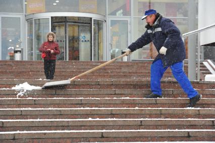 Москва. Снегопад. Мужчина чистит снег. 11 ноября 2011 года.