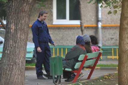 Сантехник разговаривает с жильцами дома. Москва. 21 сентября 2011 года.