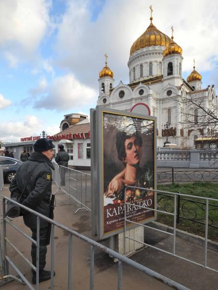 Храм Христа Спасителя. На снимке: полицейский стоит у рекламного постера с надписью КАРАВАДЖО. 18 ноября 2011 года.