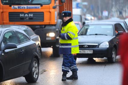 Полицейский стоит посреди дороги с рацией в руках ,Москва, 26 ноября 2011 года