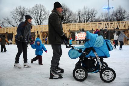 В Центральном парке культуры и отдыха имени Горького открылся зимний каток. На снимке: родители с ребенком и детской коляской во время катания на коньках.  03 декабря 2011 года.