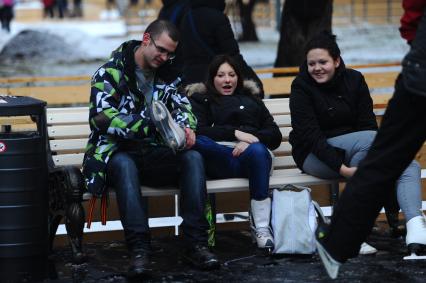 В Центральном парке культуры и отдыха имени Горького открылся зимний каток. На снимке: молодой человек одевает девушке коньки. 03 декабря 2011 года.