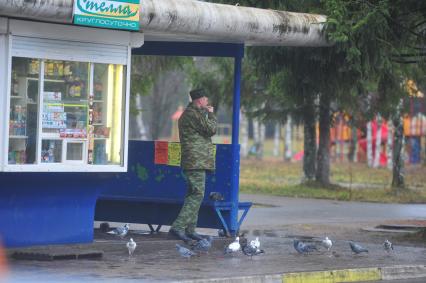 Военнослужащий грызет семечки на автобусной остановке, Плесецк, 03 ноября 2011 года