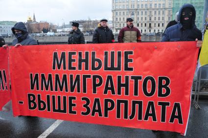 Участники санкционированного митинга против фальсификации результатов прошедших выборов в Госдуму РФ ЗА ЧЕСТНЫЕ ВЫБОРЫ на Болотной площади. На снимке: молодые люди держат плакат МЕНЬШЕ ИММИГРАНТОВ - ВЫШЕ ЗАРПЛАТА. Москва. 11 декабря  2011 года.