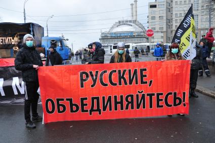 Участники санкционированного митинга против фальсификации результатов прошедших выборов в Госдуму РФ ЗА ЧЕСТНЫЕ ВЫБОРЫ на Болотной площади. На снимке: молодые люди держат плакат РУССКИЕ, ОБЪЕДИНЯЙТЕСЬ!. Москва. 11 декабря  2011 года.