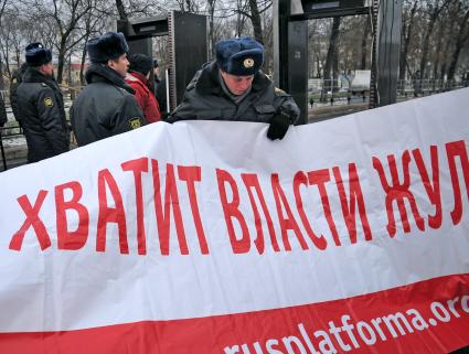 Во время санкционированного митинга против фальсификации результатов прошедших выборов в Госдуму РФ ЗА ЧЕСТНЫЕ ВЫБОРЫ на Болотной площади. На снимке: полицейский рассмтривает плакат. Москва. 11 декабря  2011 года.