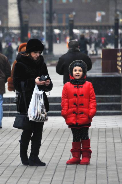 Москва центр города, люди. Мама с дочкой стоит на площади. 15 Декабря 2011 года